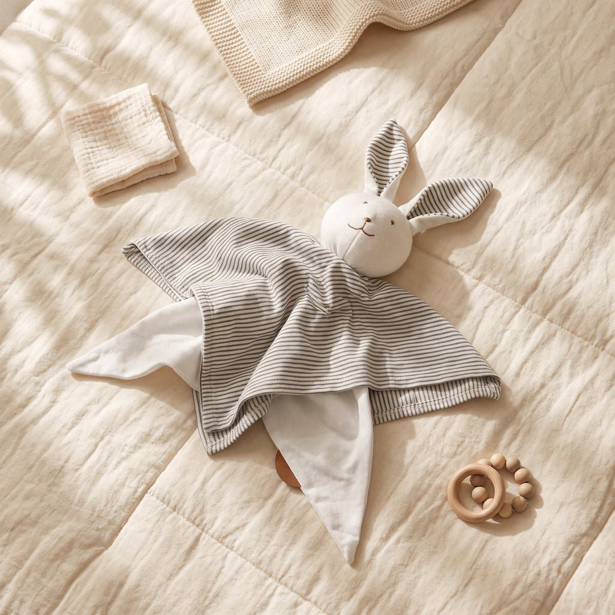 Charcoal-striped Little Bunny comforter toy laid flat, showing its fabric ears and white underside