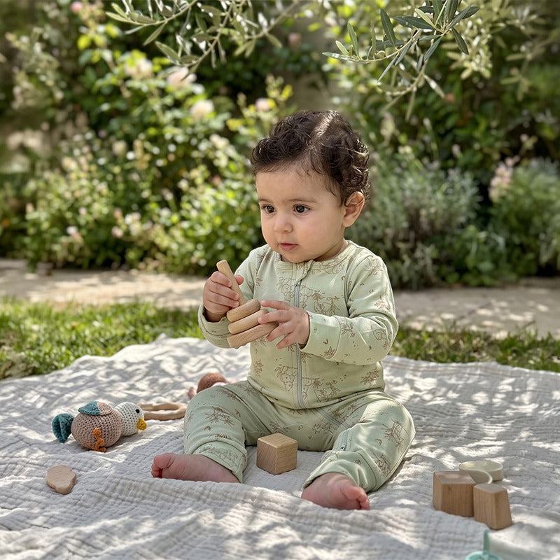 Baby playing with wooden blocks in the Panda Cotton Jumpsuit in Pistage