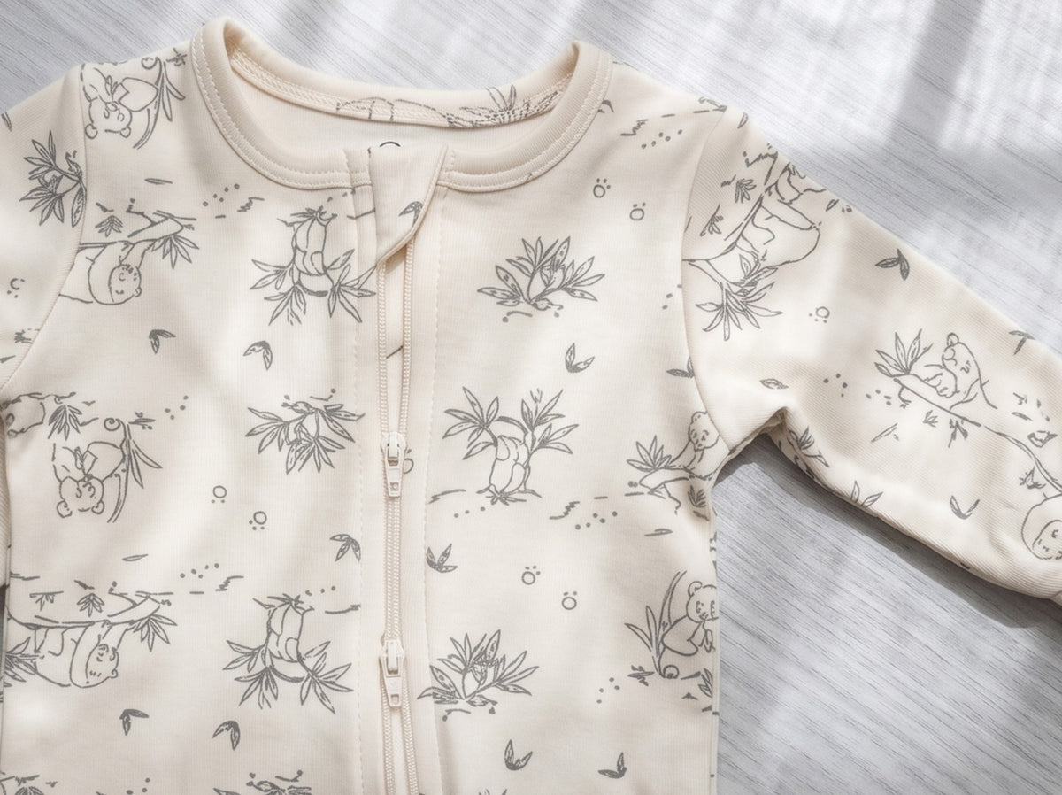 Close-up of the two-way zipper and grey panda print on the White Alyssum jumpsuit