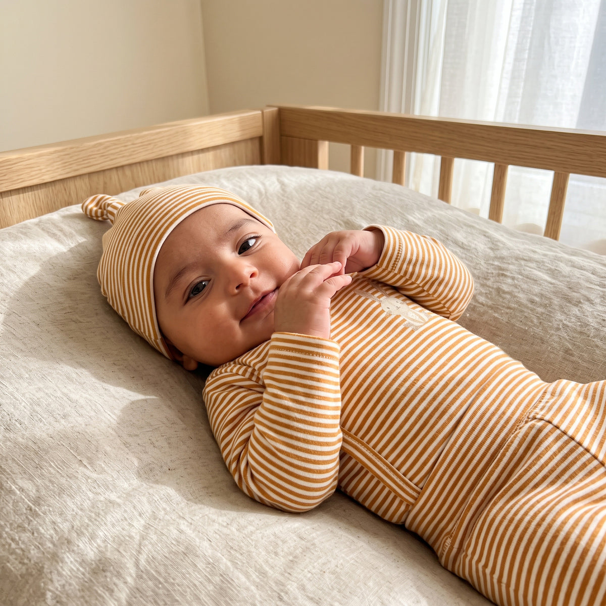 Baby wearing the Little Bunny camel-striped kimono set and matching hat